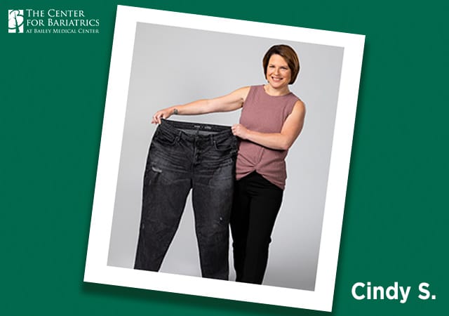 cindy holding up pair of pants several sizes too big