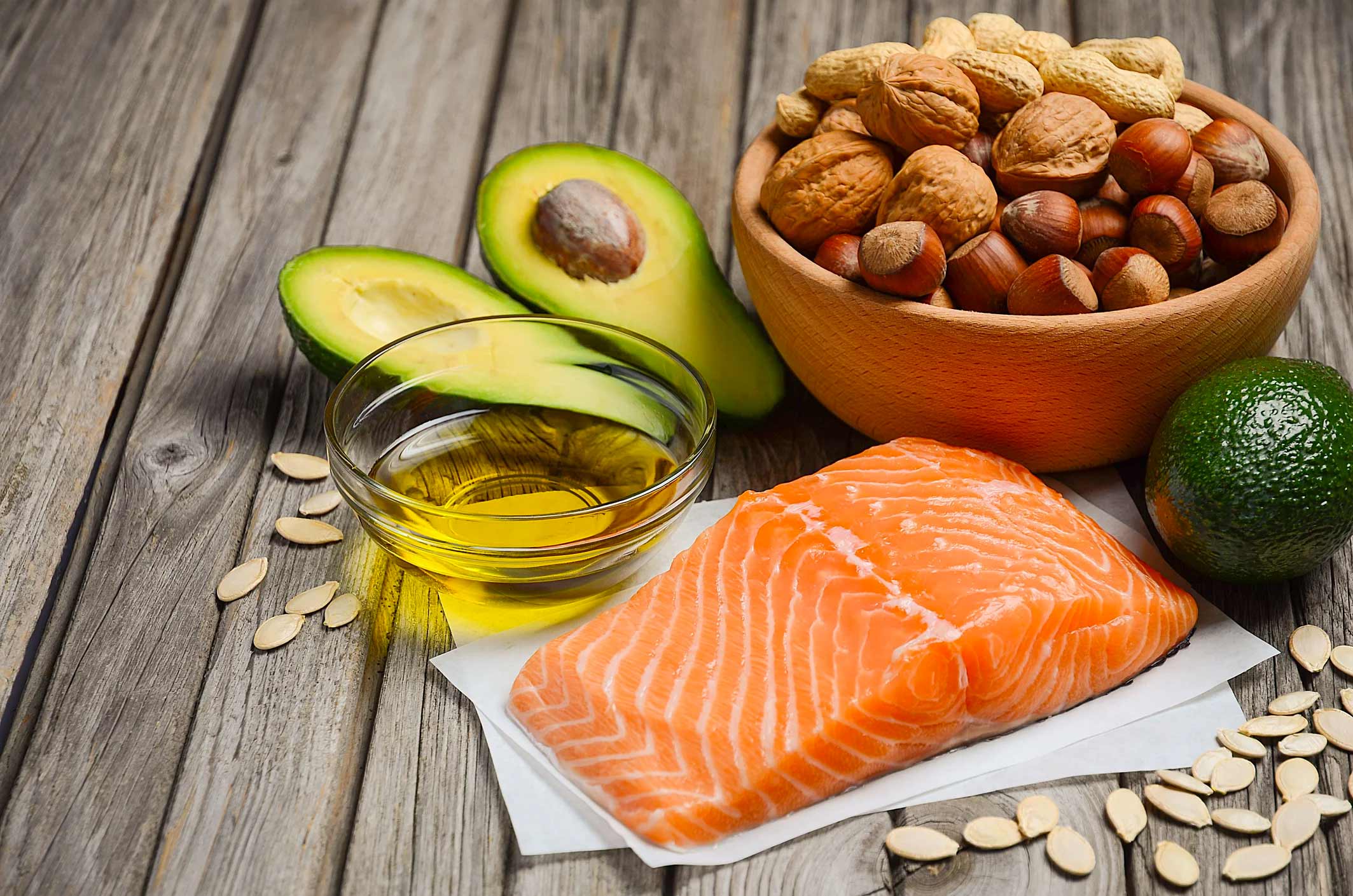 fish, avocados, oil, and nuts next to each other