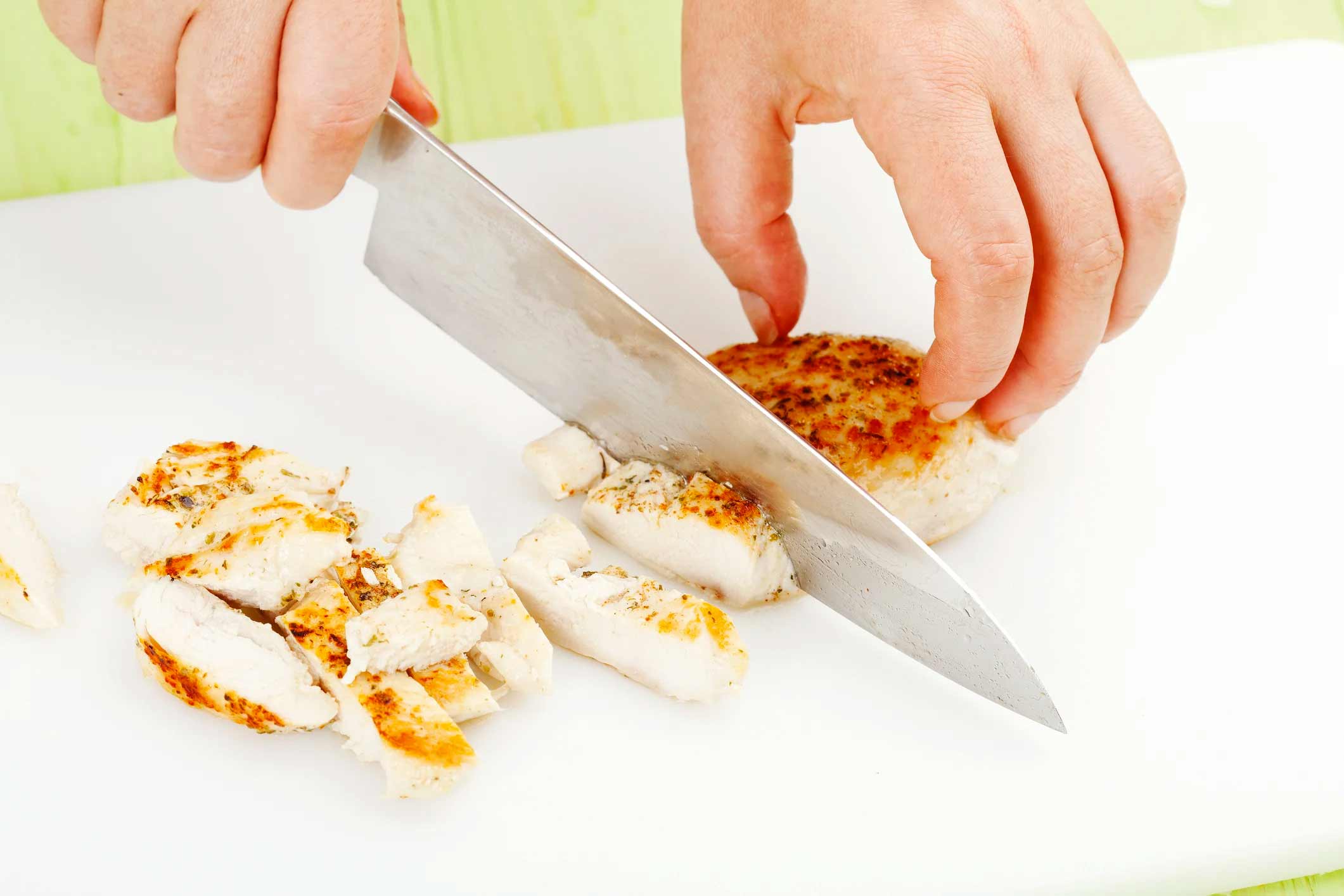 knife slicing strips of chicken
